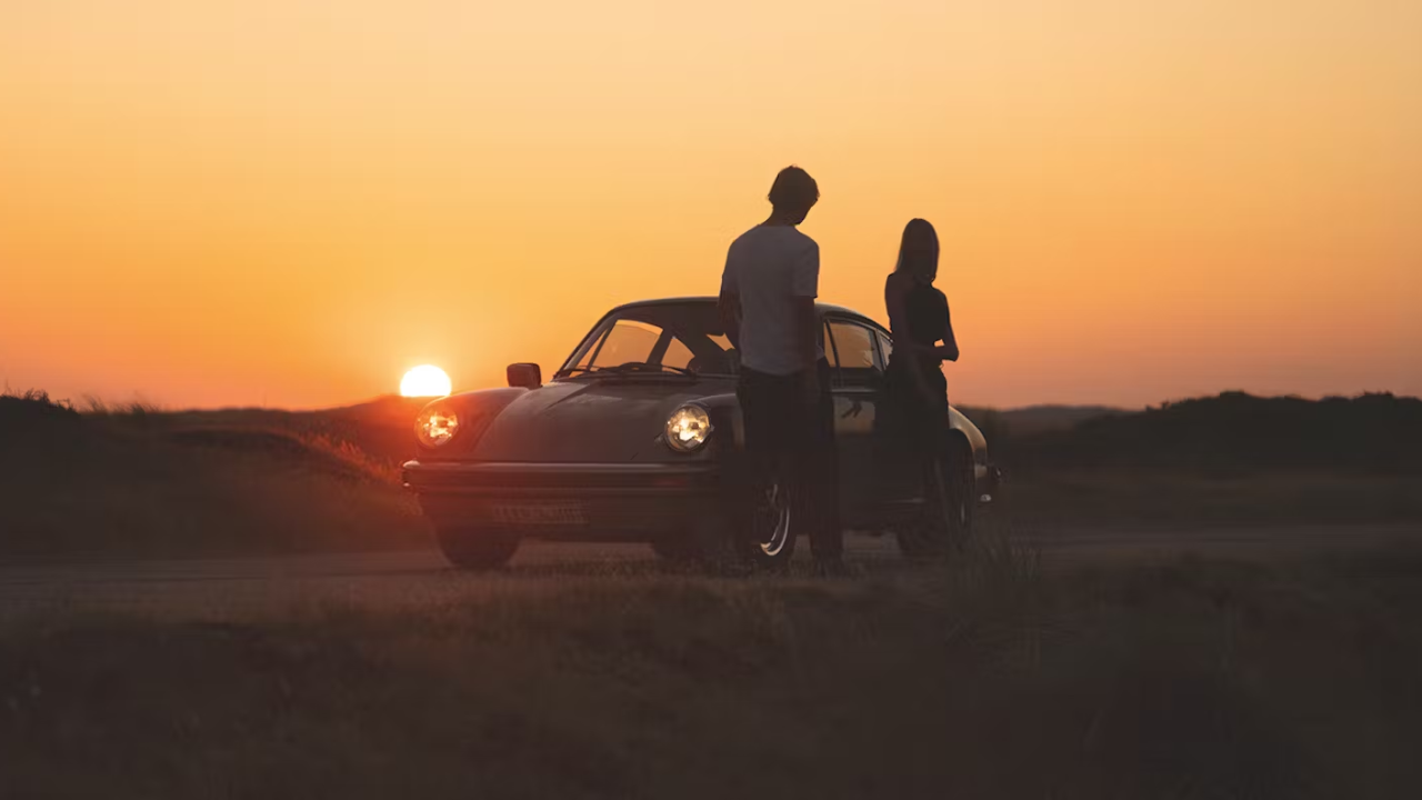 Couple with Porsche sports car – lifestyle and prestige statement
