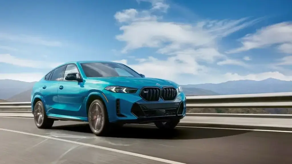 BMW X6 M Sport driving on a highway showing its coupe-SUV profile